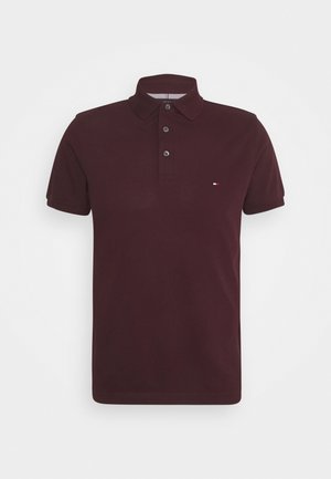 Bordeauxrode polo met korte mouwen, kraag, drieknopenbies en klein geborduurd logo aan de linkerborst.