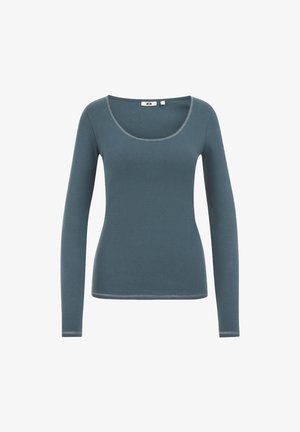 Garais piedurknes piesātināts teal tops ar izgrieztu kakla izgriezumu un redzamām šuvēm apkaklē, aprocēs un apakšmalā uz baltas fona.