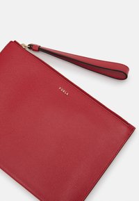 Red textured leather wristlet pouch with gold zipper and Furla logo embossed on front.