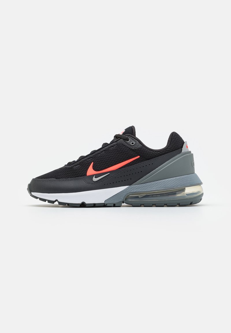 Černé a šedé tenisky Nike Air Max s jasně červenými a malými stříbrnými swooshi, viditelnou vzduchovou podrážkou a bílou mezipodrážkou na bílém pozadí.