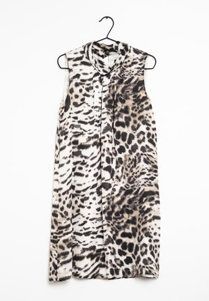 Ärmelloses knielanges Kleid mit animalischem Muster in Schwarz, Beige und Weiß, aufgehängt an einem schwarzen Kleiderbügel vor weißem Hintergrund.