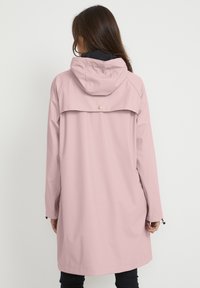 Roze, waterdichte jas met capuchon, voorzien van een achterklep, drukknoopsluiting en lange mouwen. Soepele textuur en licht oversized ontwerp.