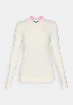 Lange mouwen, geribbelde trui in crème met een roze gestreepte kraag. Beschikt over een klein logo op de borst. Zachte textuur en aansluitend ontwerp.