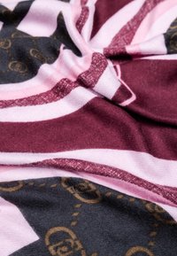 Tessuto multicolore con righe audaci in bordeaux, rosa e nero. Include accenti testurizzati e un motivo sottile con motivi circolari.