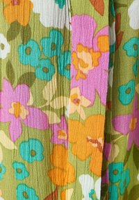 Blomstret stof i nuancer af grøn, pink, orange og blå. Har en struktureret, rynket overflade med en række blomstermønstre.