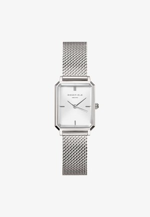 Montre avec un bracelet en maille argentée et un boîtier octogonal ; le cadran blanc présente des marqueurs horaires et des aiguilles minimalistes ; le logo est affiché à 12 heures.