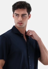 Marineblaues Kurzarmhemd mit Kragen, durchgeknöpftem Vorderteil und glatter Stoffstruktur. Geeignet für legere oder halbformelle Anlässe.