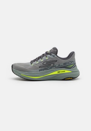 Gray running shoe with a breathable mesh upper, green accents, and a thick cushioned sole. Features include prominent branding and reflective details.