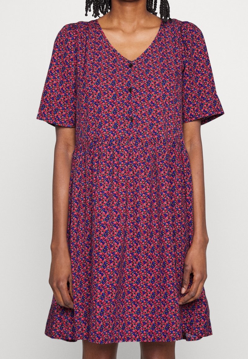 Robe à manches courtes et col en V en tissu violet foncé, ornée de motifs floraux colorés, avec un devant boutonné et une jupe évasée.