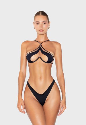 Set di bikini nero con design a taglio, spalline sottili e copertura minimale. Texture liscia con dettagli a contrasto lungo i bordi.