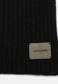 Écharpe noire en tricot côtelé avec une apparence texturée. Présente une étiquette rectangulaire en cuir gris avec "ALLSAINTS" embossé en noir.