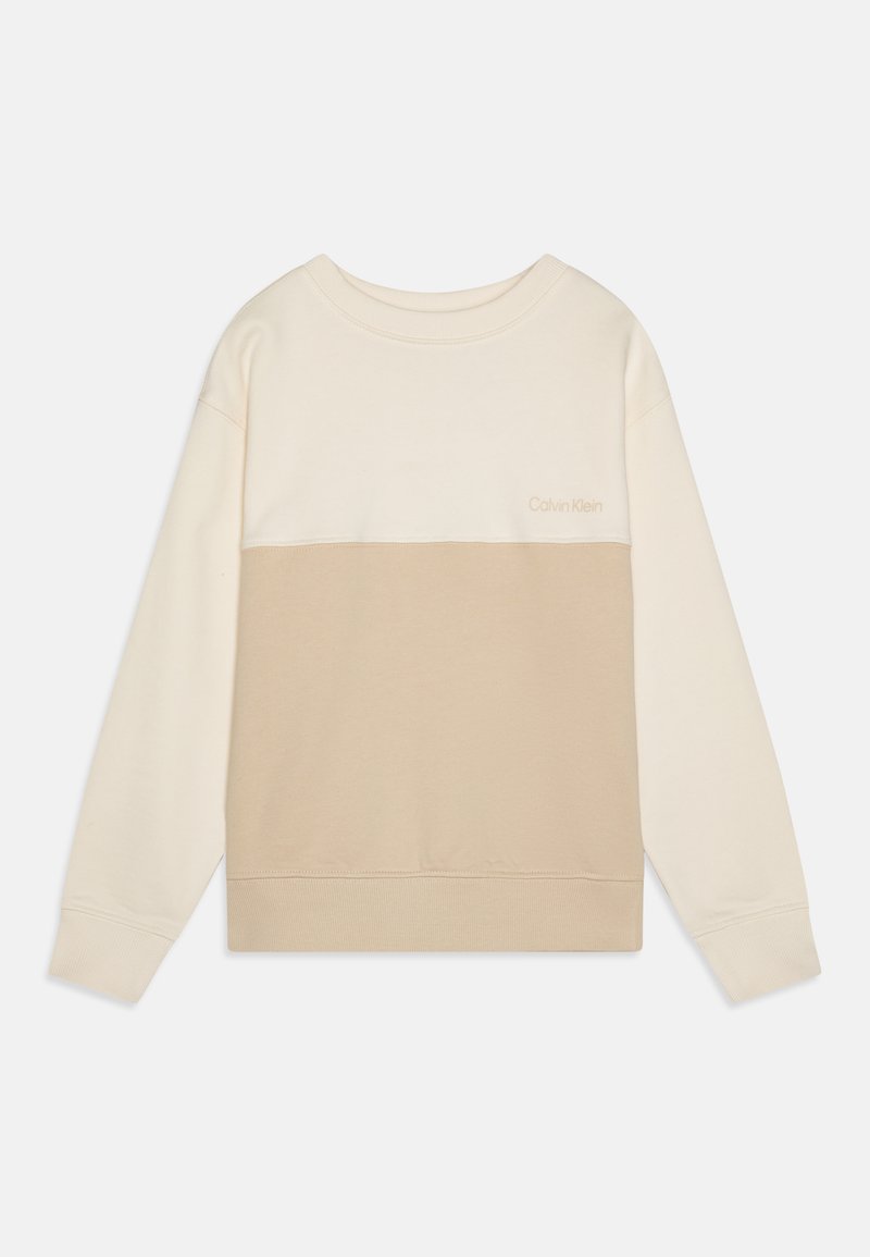 Krem- og beige fargeblokkert genser laget av mykt stoff, med rund hals, lange ermer og en subtil logo på brystet.