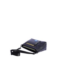 Bolso cruzado de cuero negro con superficie texturizada, bolsillos con cremallera y una correa desmontable con el nombre de la marca en negro. Botón de acento azul.