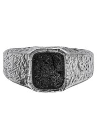 Kvadrāta formas sudraba gredzens ar teksturētu, raupju virsmu un matētu melnu akmeni centrā; ar izteiktiem leņķiem un malām.