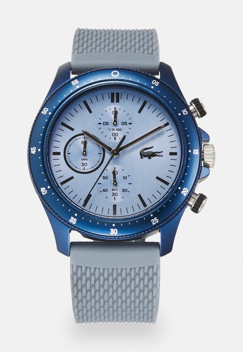 Reloj cronógrafo analógico azul con una esfera azul claro, correa de goma texturizada gris y tres subesferas para minutos, segundos y décimas de segundo.