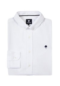 Camisa blanca de botonadura fabricada en algodón, con un pequeño logo de un árbol en azul marino en el pecho, con puños abotonados y cuello doblado.