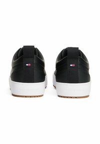 Schwarze Low-Top-Sneaker aus glattem Leder und Stoffdetails, mit weißer Gummisohle und einer Zuglasche an der Rückseite. Mit kleinem Markenlogo-Akzent.