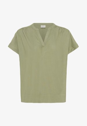 Haut vert pâle à manches courtes en tissu doux, avec un col en V discret et des fronces aux épaules pour plus de texture.