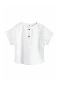 Blusa blanca de manga corta hecha de algodón texturizado, con un cuello redondo y dos botones de madera en el frente.