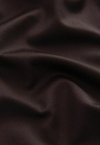 Tela lisa de color marrón oscuro con pliegues suaves y una sutil textura tejida visible en primer plano.