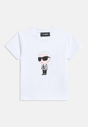 Biele tričko s krátkym rukávom s kreslenou postavou v čiernych slnečných okuliaroch, v pruhovanej bunde a s fotoaparátom uprostred hrude.