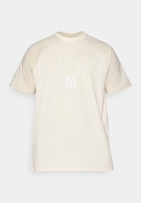 Kremfarget T-skjorte med korte ermer og rund hals, som har hvit "NEW YORK YANKEES" trykk og logo på forsiden.