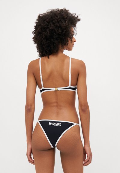 Juodas bikini maudymosi kostiumėlis su baltais akcentais, turintis plonus dirželius ir auksinę sagtį. Apačia dekoruota logotipo raštu ir turi paprastą, klasikinį dizainą.