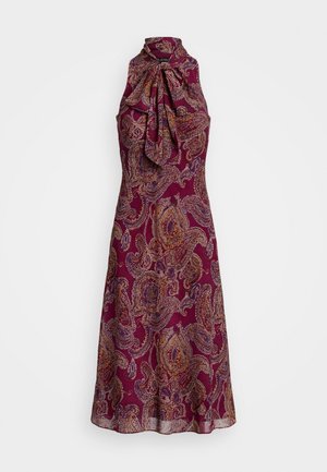 Robe violette à col halter avec un détail en noeud ; présente des motifs paisley complexes en jaune, orange et bleu. Étoffe légère avec une silhouette fluide.
