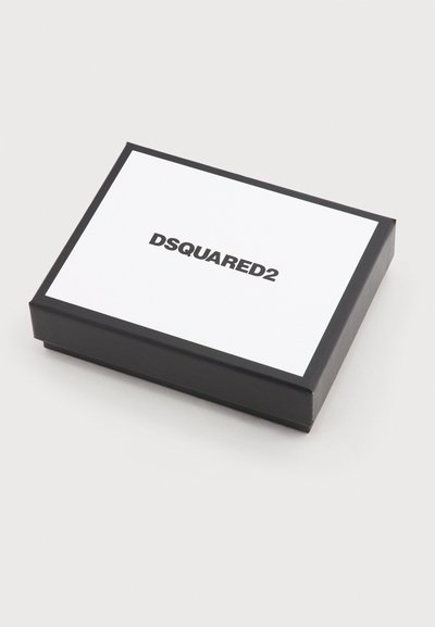 Μαύρο ορθογώνιο κουτί με λευκό καπάκι που φέρει το λογότυπο "DSQUARED2" σε μαύρο κεντραρισμένο κείμενο, τοποθετημένο πάνω σε απλό ανοιχτό γκρι φόντο.