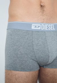 Gray cotton boxer briefs with a light gray waistband featuring white "DIESEL" branding, smooth texture, and snug fit.