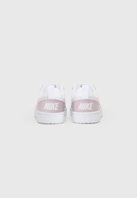 Nike sneakers in white with light pink accents. Features a smooth upper, logo on the heel, and a textured rubber sole.