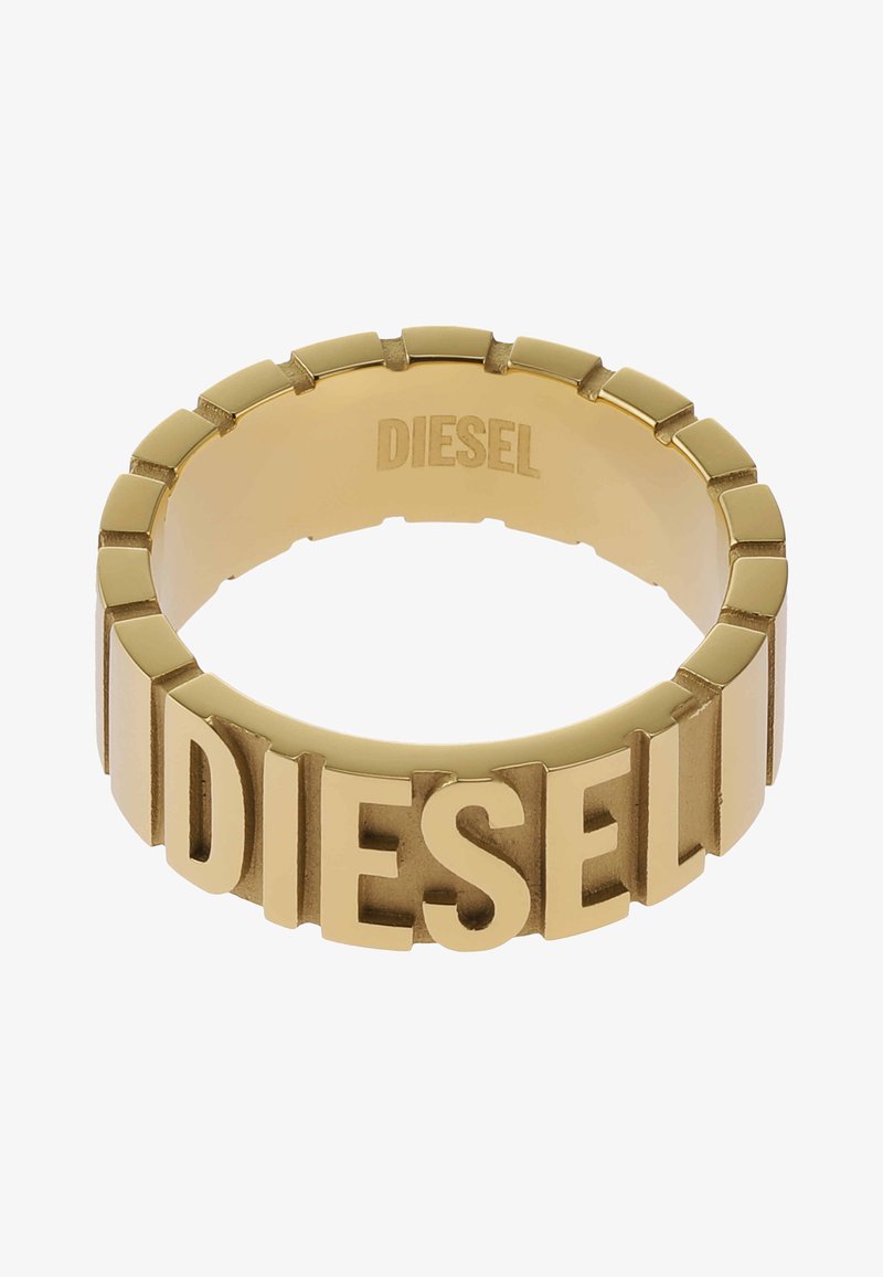 Zlatý prsten s výrazným nápisem "DIESEL" v tučných, blokových písmenech, se segmentovaným designem, který zvýrazňuje jeho hladký metalický povrch.