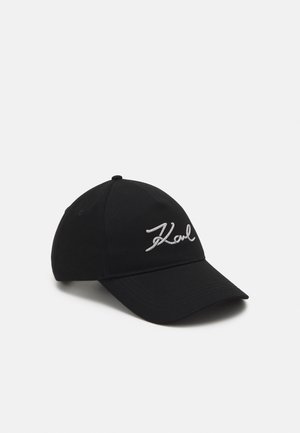 Black baseball cap with curved brim and white embroidered "Karl" script on the front, shown against a plain background.