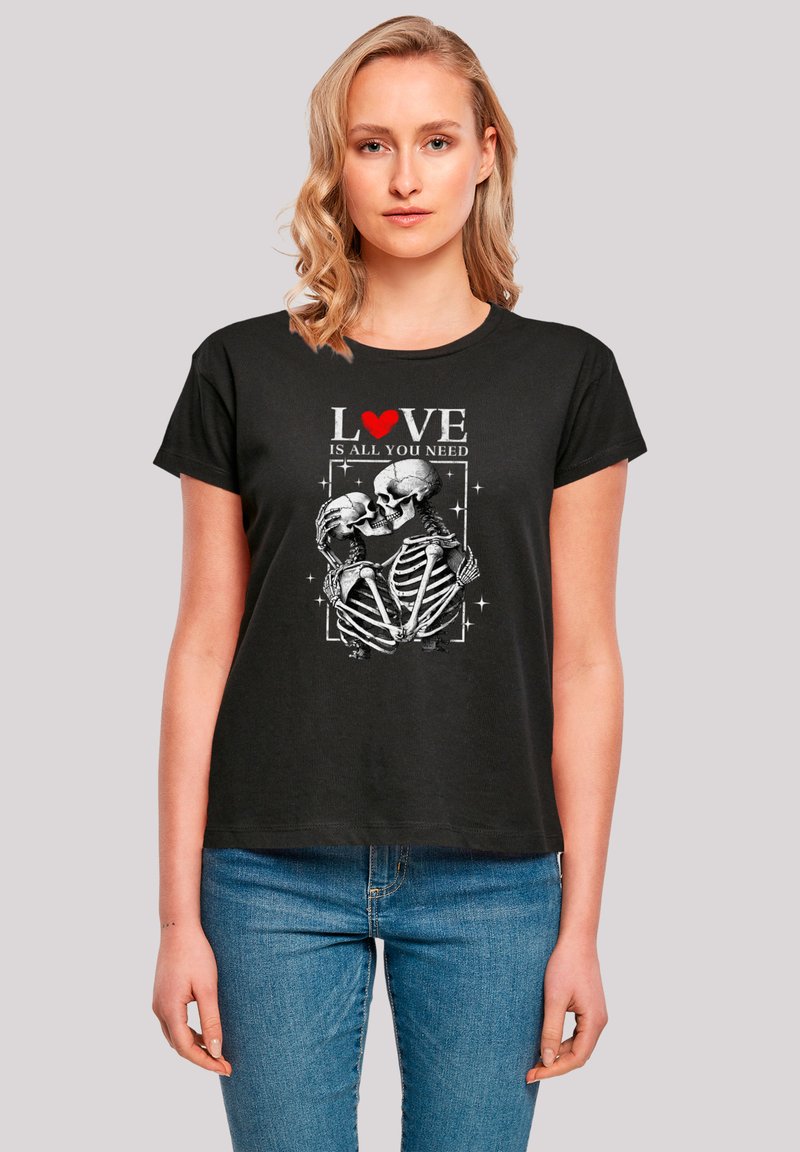 Black short-sleeve t-shirt featuring a graphic of two skeletons embracing, with the text "LOVE IS ALL YOU NEED" in white and red above.