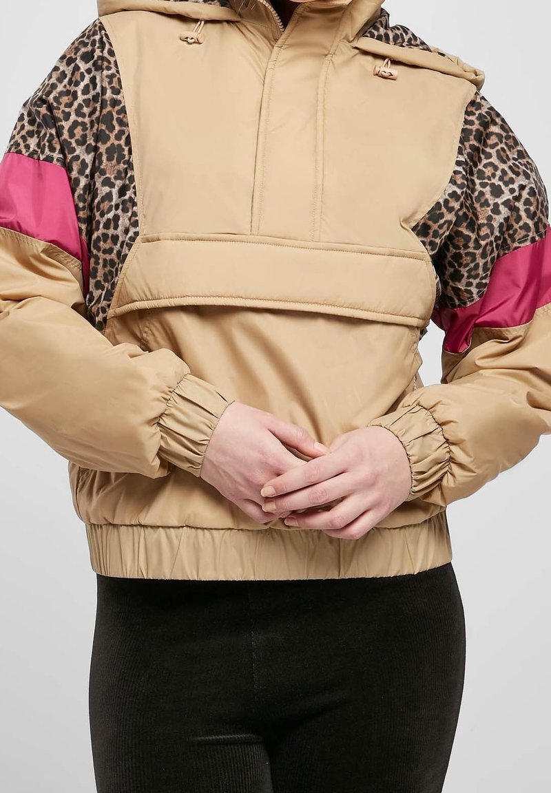Kurtka pulower w kolorze khaki z rękawami w panterkę i różowymi akcentami. Posiada elastyczne mankiety, kaptur ze ści�ągaczem oraz krótki fason.