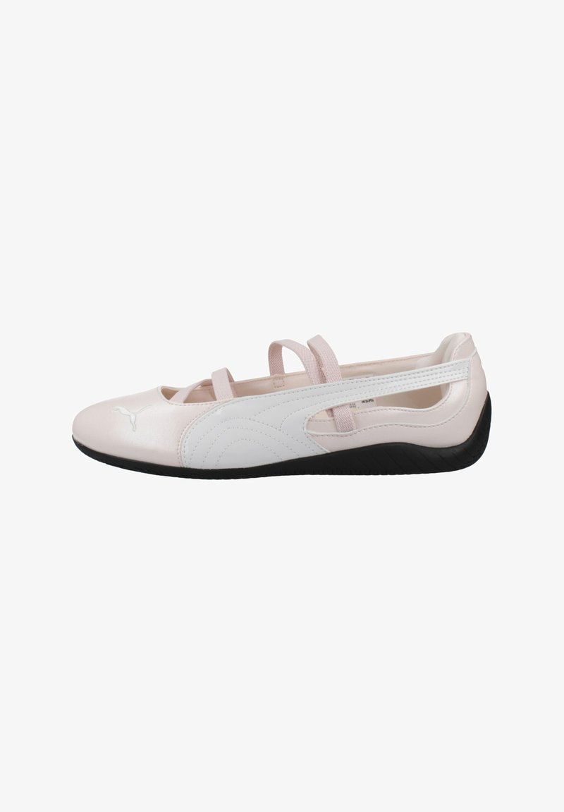 Chaussure plate de style ballet en rose clair et blanc avec une semelle noire, des sangles élastiques sur le dessus et un logo Puma près des orteils.