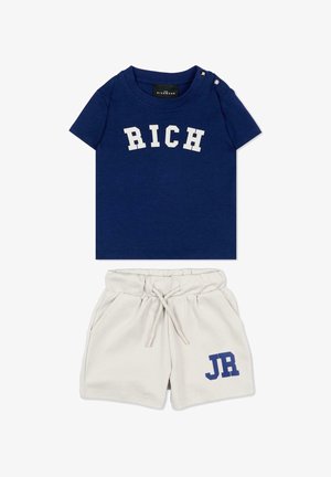 Navyblauw T-shirt met korte mouwen met de tekst "RICH" en beige short met trekkoord en blauwe tekst "JR" op het linkerbeen.
