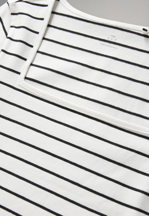 T-shirt in tessuto bianco con strisce nere, con scollo quadrato e texture morbida. L'etichetta riporta "THE SET, MADE IN BANGLADESH."