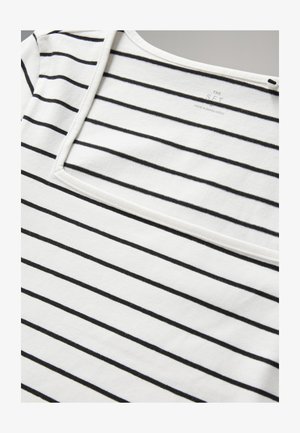 Wit stoffen T-shirt met zwarte strepen, voorzien van een vierkante halslijn en een zachte textuur. Het label zegt "THE SET, MADE IN BANGLADESH."