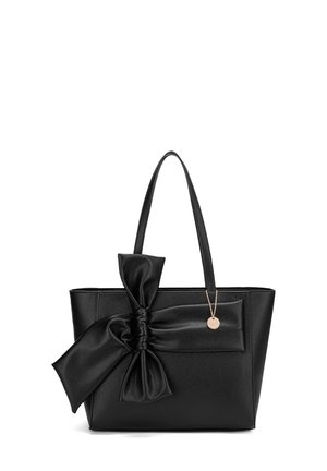 Sac fourre-tout en cuir noir avec un nœud proéminent à l'avant. Présente une texture lisse, deux anses et un accent en métal.