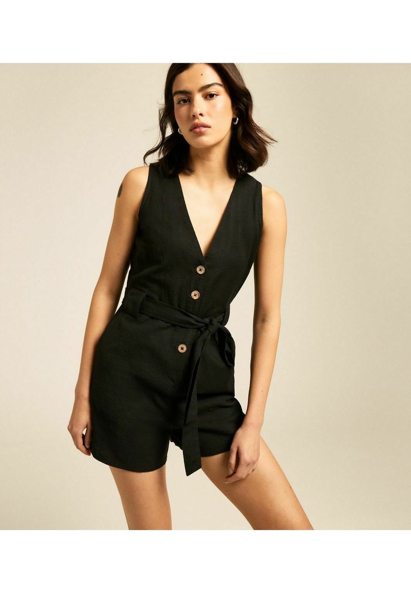 Rompers en lin noir avec un décolleté en V profond, une fermeture à boutons à l'avant et un détail à nouer à la taille. Présente une conception sans manches et un tissu texturé pour un look décontracté.