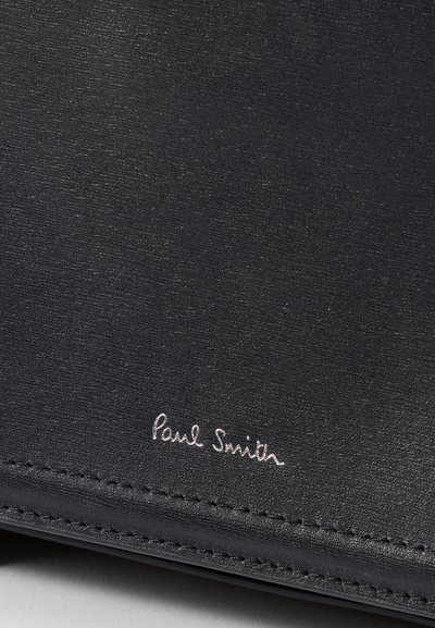 Portafoglio in pelle nera con una texture liscia, caratterizzato da una leggera lucentezza e cuciture tonali, logo "Paul Smith" in rilievo in argento.