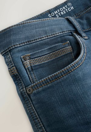 Bequeme Stretch-Denim-Jeans in mittlerem Blau, mit einer Vordertasche mit sichtbarer Naht und zwei Metallknöpfen an der Taschenkante.