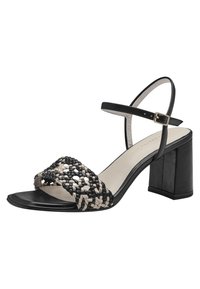 Flätad svart och krämfärgad sandal med blockklack och vristrem. Har öppen tå och texturerad ovandel. Slät sula och minimalistisk design.