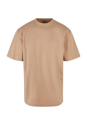 Camiseta de manga corta color beige, hecha de algodón. Presenta un cuello redondo y un corte relajado. Textura suave sin patrones o acentos visibles.