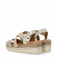 Sandalias de cuña con una parte superior de tejido beige texturizado, tiras metálicas plateadas y una suela de plataforma de madera en capas con base de goma.