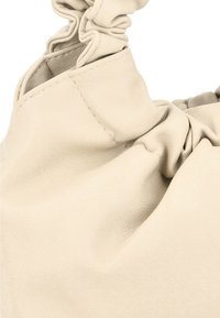 Borsa a mano in pelle beige con design arricciato, texture morbida e dettagli di cucitura a vista. Focus sulla forma unica e sull'eleganza informale.