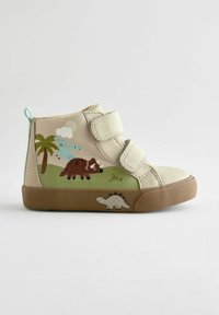 Beige canvas barnens högstövlar med två kardborreband, med färgglada dinosaurie- och palmträdsmönster, samt en brun gummisula.