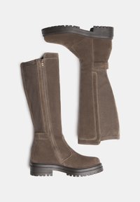 Knee-high brown suede boots with textured finish, side zipper, and thick black rubber soles featuring rugged tread.
