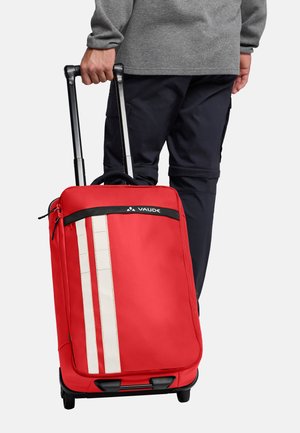 Valigia rossa con ruote, superficie liscia, due strisce bianche verticali, maniglia superiore e maniglia nera retraibile. Materiale resistente con un design strutturato.